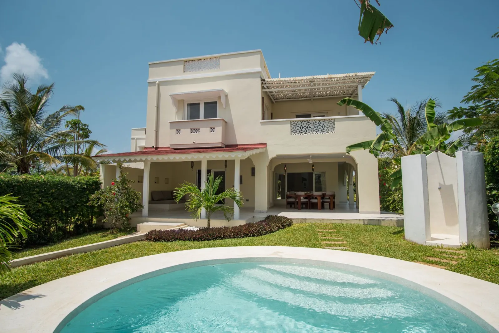 A white villa and its private pool in the afternoon sun