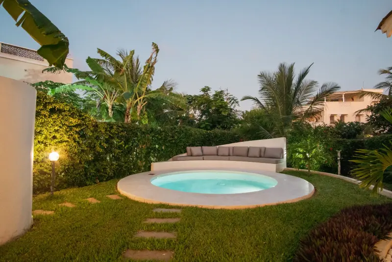 A round pool in a villa garden at sunset